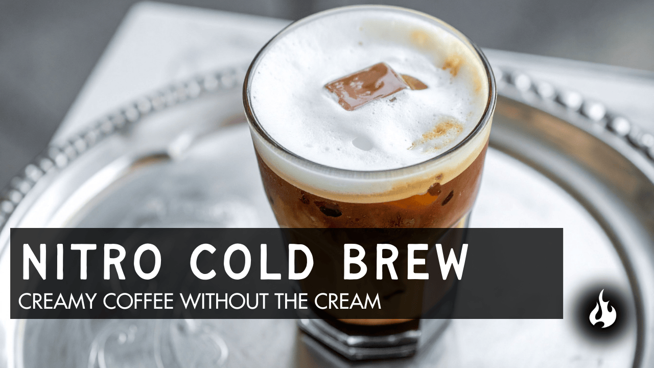 Glass of nitro cold brew coffee with foam head on silver tray