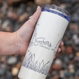 Ember Style Petal Tumbler held in hand, showing the engraved lakeshore and pine design