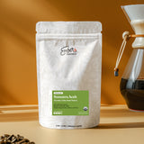 Sumatra Aceh medium-dark roast single origin, 4 oz sample bag, beside a Chemex brewer, lifestyle